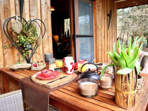 a wooden table with a tea set on a porch at La Linotte in Arville