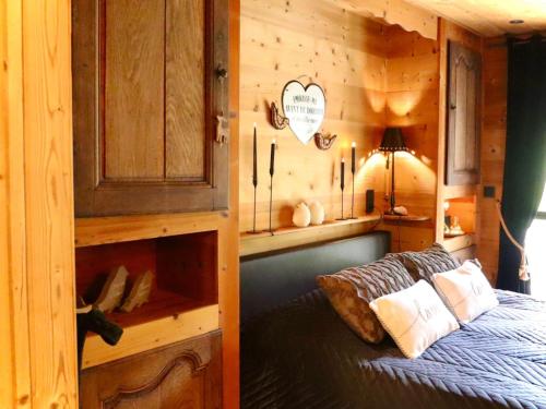 a bedroom with a bed in a wooden cabin at La Linotte in Arville
