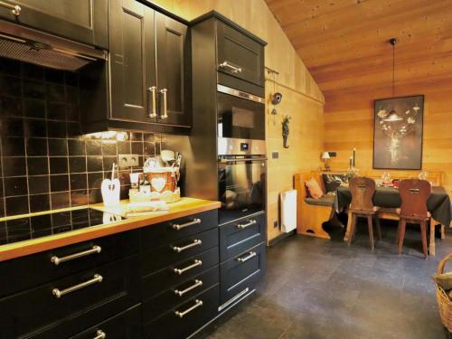 a kitchen with black cabinets and a dining room at La Linotte in Arville