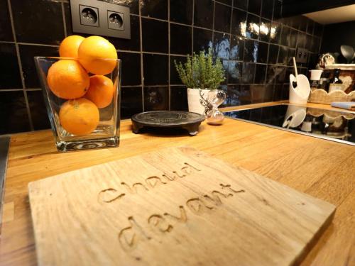 a sign on a kitchen counter with oranges in a vase at La Linotte in Arville