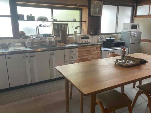 a kitchen with a wooden table and a table and chairs at HANARE紡舎Tsumugiya in Ogawa
