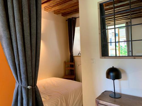 une chambre avec un lit et une fenêtre dans l'établissement Au coeur de Troyes, Atelier de la Cathédrale, à Troyes