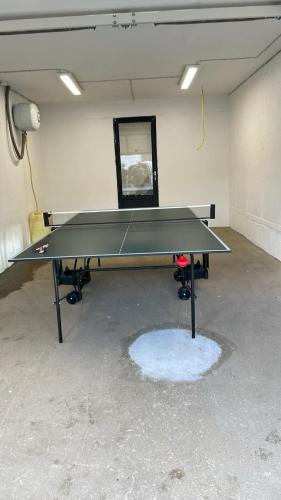 a ping pong table in a room with a ping pong ball at Eiðsvíkslon - The Red Boathouse by the Sea in Viðareiði