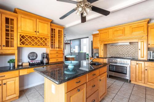 eine große Küche mit Holzschränken und einem Deckenventilator in der Unterkunft Twin Pines Retreat Hot Tub Theater Room Fire in East Stroudsburg