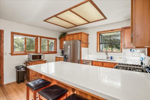 a kitchen with a white counter top and wooden cabinets at Cub House- Remodeled cabin INSIDE Yosemite with new hot tub and more in North Wawona