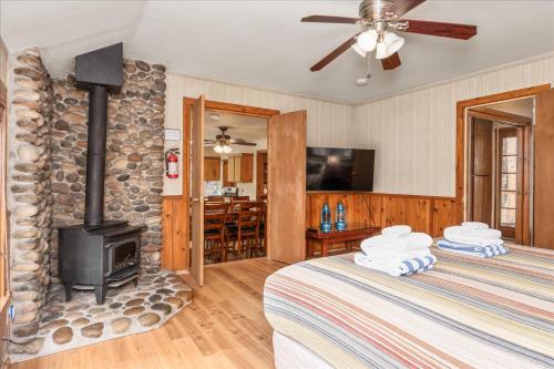 two beds in a room with a stone fireplace at Cub House- Remodeled cabin INSIDE Yosemite with new hot tub and more in North Wawona