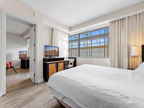 a bedroom with a bed and a desk with a television at Amazing Miami Condo in Brickell near the beach in Miami