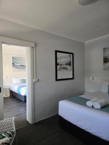 a hotel room with two beds and a window at Araluen Motor Lodge in Batemans Bay