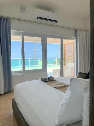 two beds in a room with a view of the ocean at Hotel Checkin El Cortecito Beach in Punta Cana
