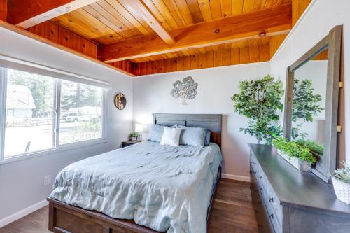 a bedroom with a large bed and a wooden ceiling at 2 Mi to Trails Modern Mountain Condo in Big Bear in Big Bear City