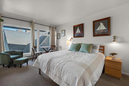 a bedroom with a bed and a chair and a window at The Tides by the Sea in Seaside