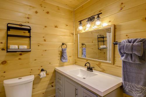 Un baño con lavabo, inodoro y espejo. en Game Room, Hot Tub, Pool and Views Gatlinburg Cabin, en Gatlinburg