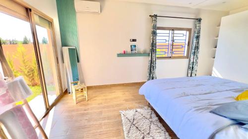 a bedroom with a bed and a large window at Villa - Dar Tura in Tikoutar