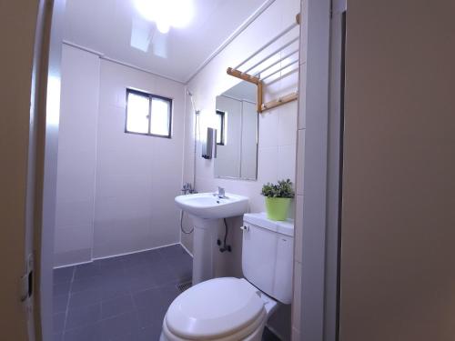 a white bathroom with a toilet and a sink at OYO Hostel Dongdaemun1 in Seoul