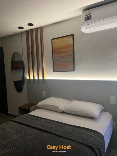 a bedroom with a bed and a picture on the wall at Flats Tramonto - By EasyHost in João Pessoa