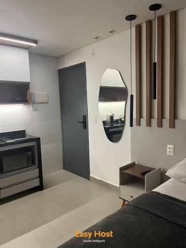 a room with a bedroom with a bed and a mirror at Flats Tramonto - By EasyHost in João Pessoa