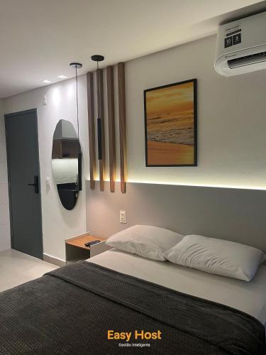 a bedroom with a bed and a picture on the wall at Flats Tramonto - By EasyHost in João Pessoa