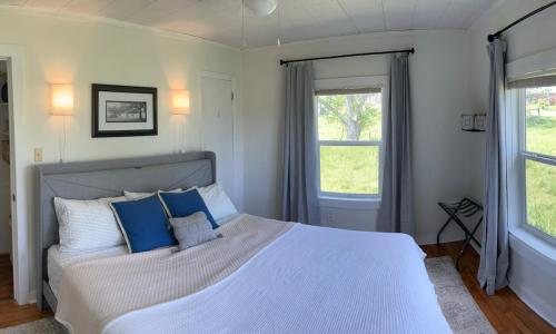 a bedroom with a large white bed with blue pillows at Mountain View Cottage in Ashland