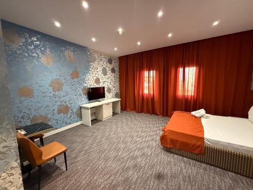 a bedroom with a bed and a tv in it at Black Mont İnn Hotel in Baku
