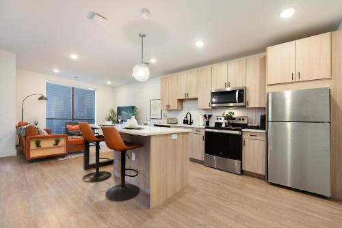 a kitchen with a refrigerator and a table with chairs at LUX Studio King Bed Free Parking Gym New in Pittsburgh