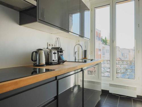 une cuisine avec un évier et un plan de travail dans l'établissement Charming flat -1BR-4P- Paris 17e, à Paris
