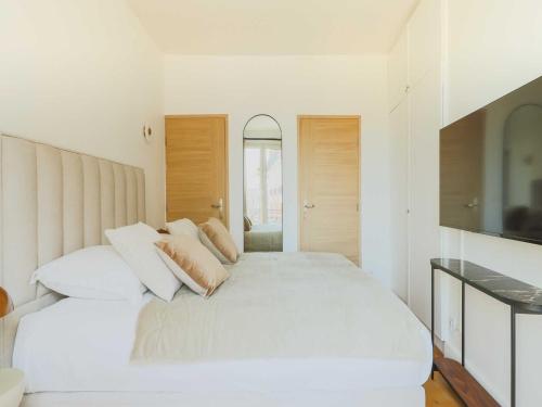 une chambre blanche avec un grand lit blanc avec des oreillers dans l'établissement Charming flat -1BR-4P- Paris 17e, à Paris