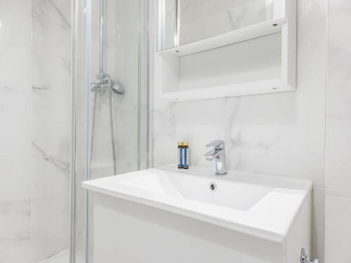une salle de bain blanche avec un lavabo et une douche dans l'établissement Intimate studio - 2P - Vincennes Lac Saint-Mandé, à Vincennes