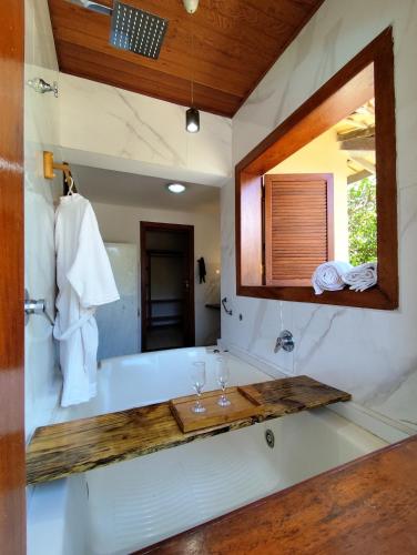 a bathroom with a tub and a mirror at Pousada Royale in Arraial d'Ajuda