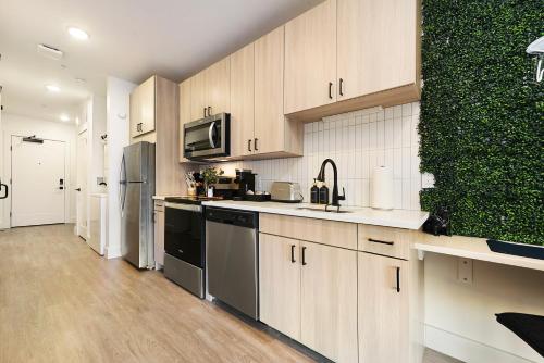 a kitchen with wooden cabinets and a green wall at King Bed, Free Parking, Near UPMC, Pitt & CMU in Pittsburgh
