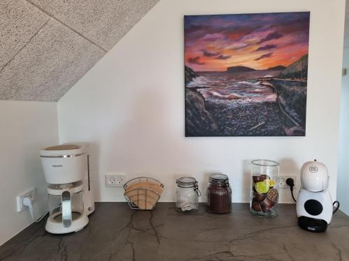 a kitchen with a coffee maker and other appliances at Eiðsvíkslon - The Red Boathouse by the Sea in Viðareiði