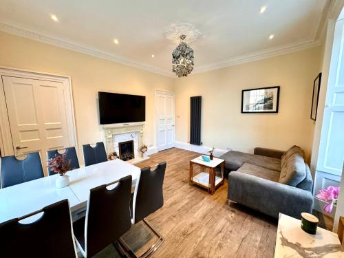 a living room with a table and a couch at Georgian Luxury Apartment - Fast Broadband WiFi - Parking Available in Edinburgh