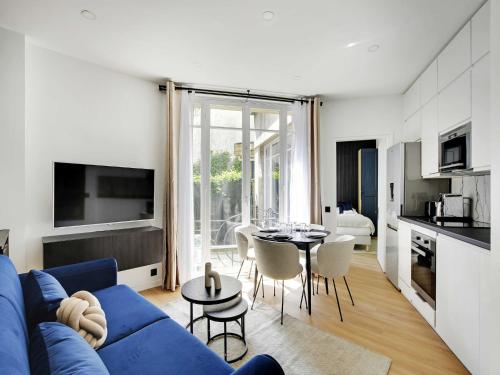 un salon avec un canapé bleu et une table dans l'établissement Magnificent 2BD 6P apartment - Eiffel Tower, à Paris
