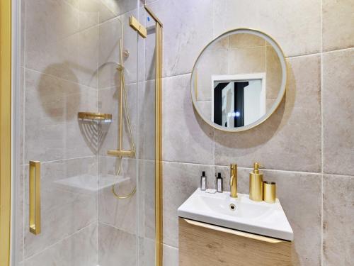 une salle de bain avec une douche avec un lavabo et un miroir dans l'établissement Magnificent 2BD 6P apartment - Eiffel Tower, à Paris
