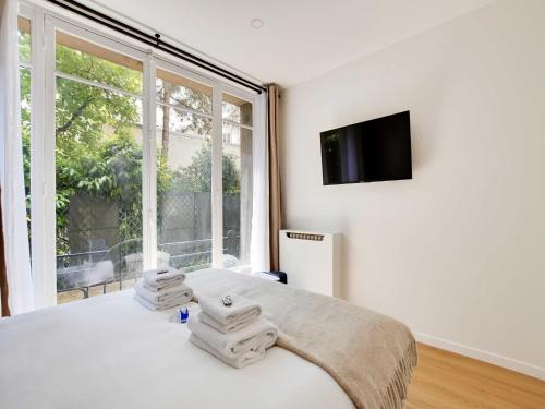 une chambre avec un lit et une grande fenêtre dans l'établissement Magnificent 2BD 6P apartment - Eiffel Tower, à Paris