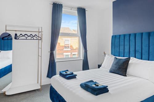 a bedroom with a bed with two blue towels on it at The Navy Nest Luxury Home Nottingham in Nottingham