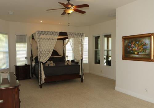 a bedroom with a bed with a ceiling fan at El Tranquillo in Templeton