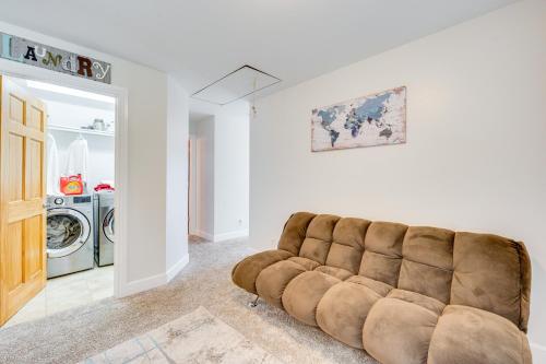 a living room with a couch and a washer and dryer at 2 Mi to Lake Estes Home with Deck and Grill in Estes Park