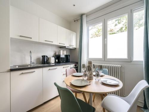 une cuisine avec une table et des chaises dans une cuisine dans l'établissement Charming apartment 2BR 6P - Place d'Italie, à Paris