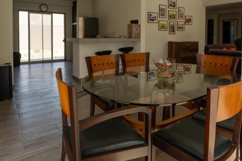 a dining room with a glass table and chairs at Ecohouse Cieneguilla in Pachacamac