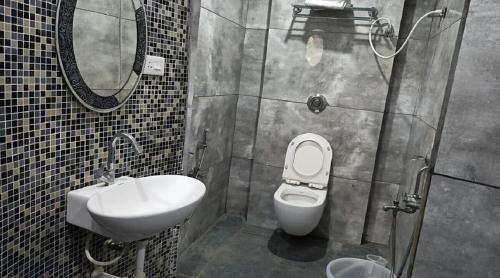 a bathroom with a sink and a toilet and a mirror at Villa Victor in Puducherry