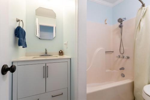 a bathroom with a sink and a tub and a mirror at Paradise between ocean and sound -A Writers Reef in North Topsail Beach