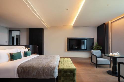 a hotel room with a bed and a tv at 黄石未苏湾花间亭飞花 in Xialu