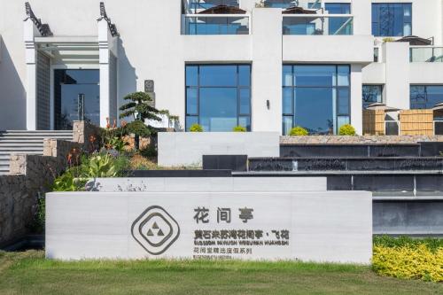 a sign in front of a building at 黄石未苏湾花间亭飞花 in Xialu