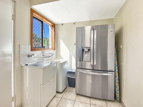 a kitchen with a stainless steel refrigerator and a window at Island Magic Townhouse 5 in Arcadia