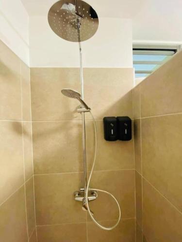 a shower with a shower head in a bathroom at Tehautahi Cozy Lodge 2 in Papeete