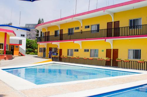 a hotel with a swimming pool in front of a building at Hotel Kazmay in Temixco