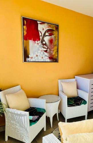 a room with chairs and a painting on the wall at Tehautahi Cozy Lodge 2 in Papeete