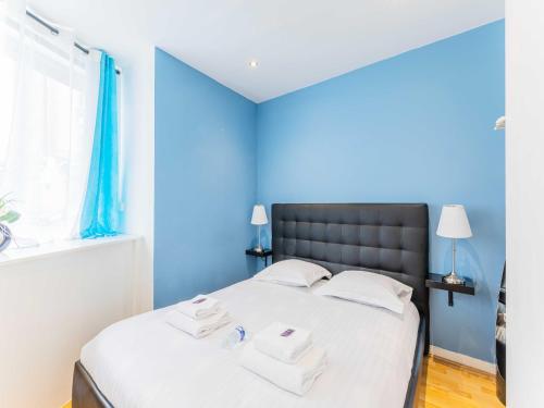 - une chambre bleue avec un lit et des serviettes dans l'établissement Quiet apartment - 1BR 4P - Sacré Coeur, à Paris