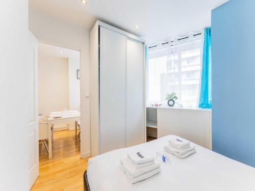 - une chambre blanche avec un lit et des serviettes dans l'établissement Quiet apartment - 1BR 4P - Sacré Coeur, à Paris