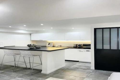une cuisine avec des armoires blanches et un comptoir noir dans l'établissement Beautiful apartment close to the Galeries Lafayette, à Paris